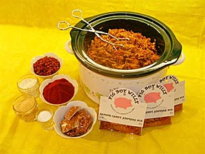 A slow cooker of carne adovada beside two Pig Boy Willy packets
